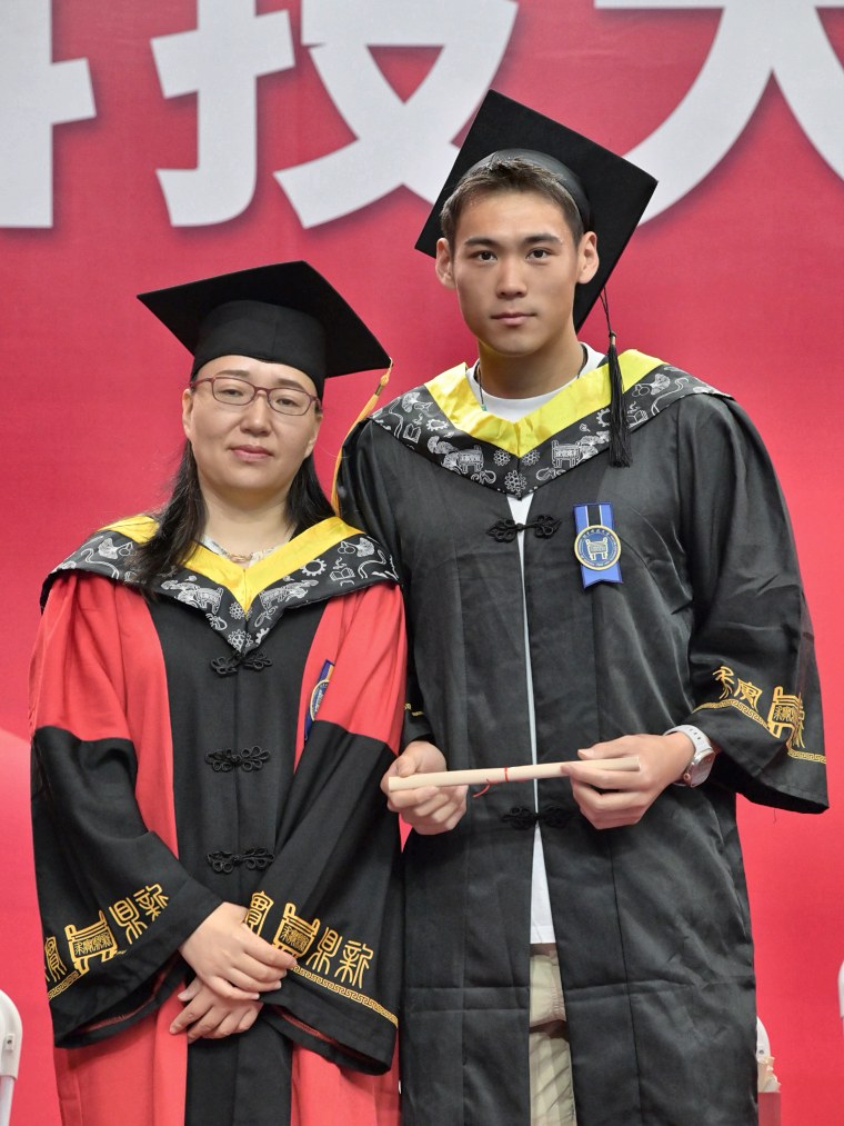 Adam Zhang in cap and gown with a professor at his USTB commencement