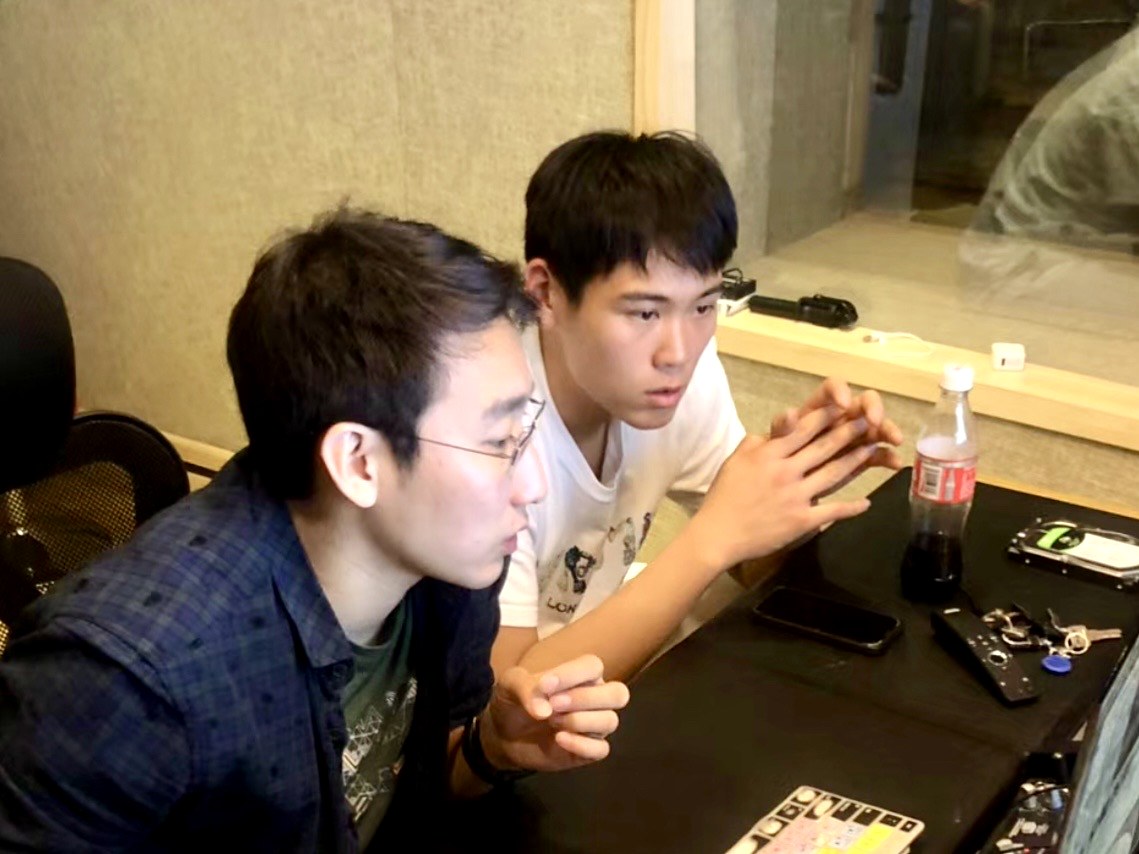 Adam Zhang in a recording studio with a producer